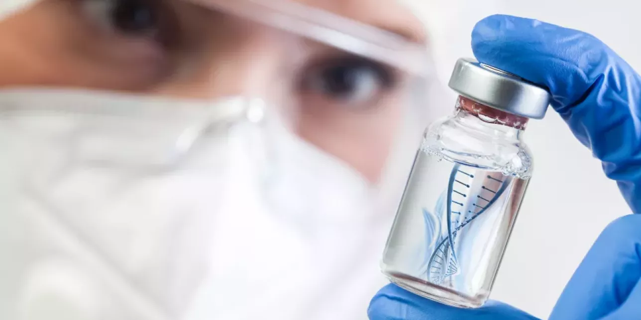 iStock Photo. Stock photo of a person holding a medicine vial with a graphical representation of DNA inside the vial.