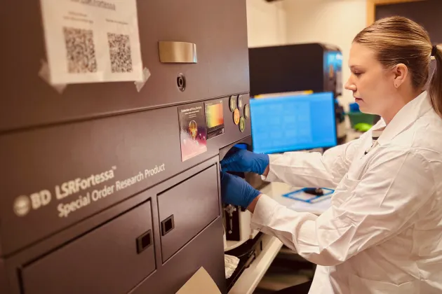 Alice Hägg using a flow cytometer in the FACS Core Facility.
