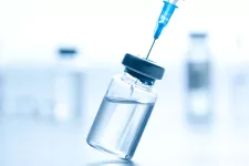 Photo of a syringe being injected into a vial full of liquid. 